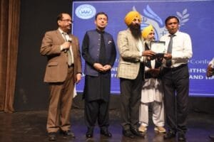 Minister presenting a shield to Mr. Shahzad Lawrence
