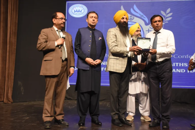 Minister presenting a shield to Mr. Shahzad Lawrence