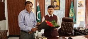 Mr. Shahzad Lawrence is presenting a bouquet to commissioner