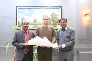 Shahzad Lawrence and Rev. Arif Siraj are presenting flowers to Sardar Ghias Gul Khan